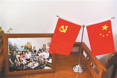 越秀区东湖新村社区一户居民家中，茶几上的“全家福”旁摆放着国旗和党旗。