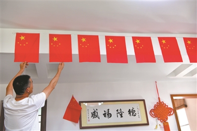 东湖新村社区居民在家中悬挂国旗，喜迎国庆。