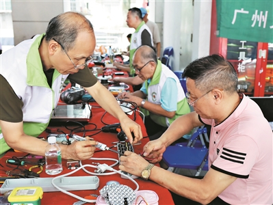 广州粤晖家电志愿服务维修队为居民维修电器。