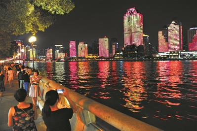 在滨江路散步的市民纷纷拿起手机拍摄对岸的美景。