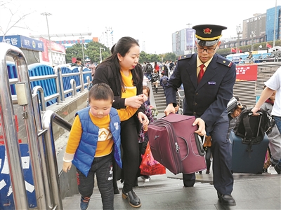 钟永涛帮旅客提行李出站。