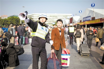 2018年2月1日，广州火车站的执勤人员在为乘客指路。