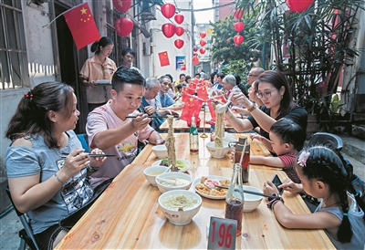 青年们与街坊同吃“国庆面”。