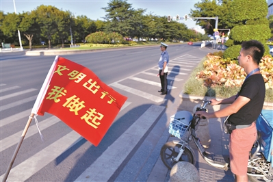 广州会展西路新港东路口，路人有序过马路。