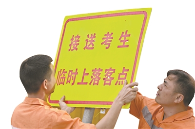考点外的工作人员布置交通指引设施。
