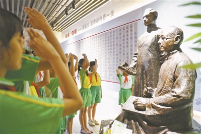 小学生在纪念馆内向高剑父和高奇峰的雕像敬礼。