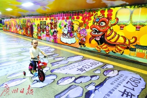 广州古城游体验馆内，一个小朋友正在“游览”壁画。
