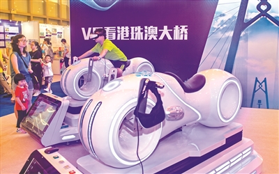 小朋友骑在炫酷的“摩托车”上通过VR看港珠澳大桥。