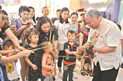 6月8日，在广州市城市规划展览中心的非遗项目展示上，小朋友体验皮影戏。