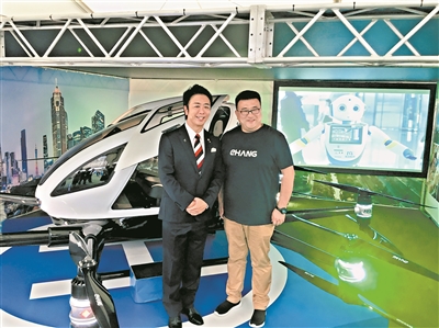 高岛宗一郎市长(左)观看亿航载人级自动驾驶飞行器在福冈展出。