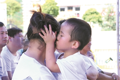 在广州的一个“关爱留守儿童”主题的活动现场，孩子深情地亲吻母亲。（资料图片）