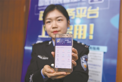 工作人员展示国家移民管理局政务服务平台办理出入境业务的页面。