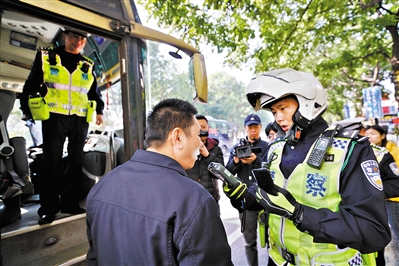 广州天河客运站附近检查点，交警正在对一位客车司机进行酒精含量检测。
