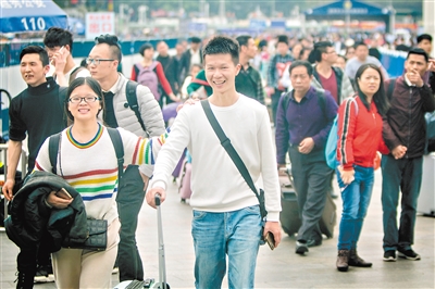 广州火车站广场，返程旅客笑着出站。