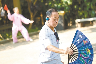 在广州市晓港公园内，晨练者戴着耳机打太极拳，以免影响到他人。
