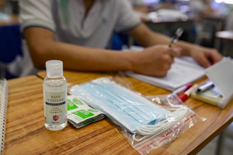 课桌上摆放着免洗洗手液、口罩等防疫用品。石建华 摄.JPG