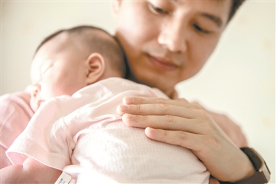赖永新化身温柔奶爸，抱着刚出生小女儿哄她入睡。