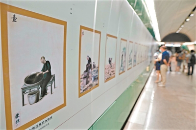 地铁内市民在观看通草画。