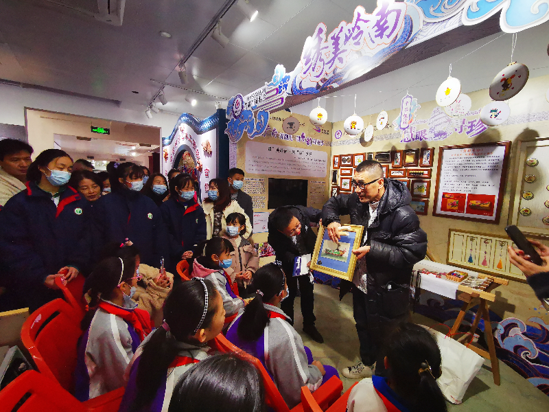 图1广州市青年美术家协会副主席梁瀚文以200多年前的通草画为例，为学生们讲解通草画的材料、技法、发展历程等知识.jpg