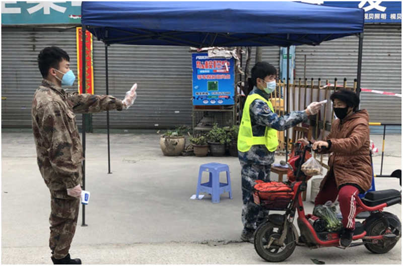广州市荔湾区退役士兵刘卫杰和伍家杰在为过往群众量体温