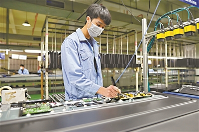 黄埔区、广州开发区某工厂生产线上，复工后的员工戴口罩工作。.jpg