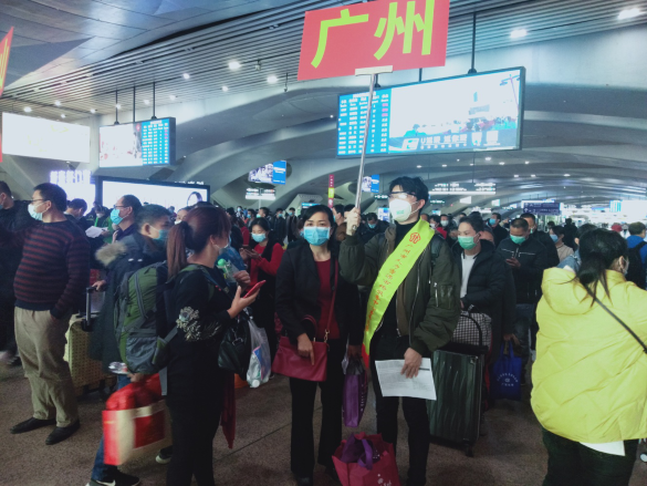 （图2：广州市人力资源市场服务中心工作人员在广州南站组织返岗务工人员排队集合上车）.png
