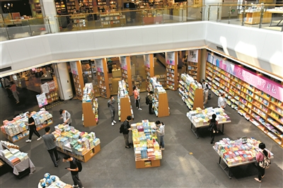 在广州购书中心，读者自觉保持1.5米左右的安全距离选购图书。