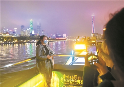 市民在游船上拍照、欣赏珠江两岸美景。