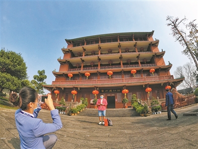  游客在广州博物馆前拍照留念。