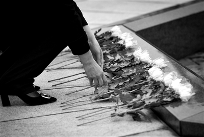 昨日，广州市银河烈士陵园工作人员向烈士墓献花。