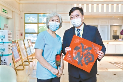 刘奶奶与酒店经理张耀宗合影。