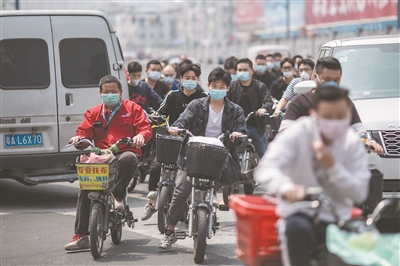 中大布匹市场附近，工人们戴着口罩返工。