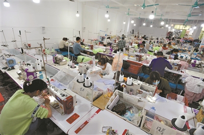 康乐村里的一家制衣作坊，工人们在生产线上忙活。