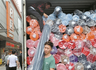 处于纺织商圈核心位置的广州国际轻纺城，货物装满车厢，工人忙着出货。